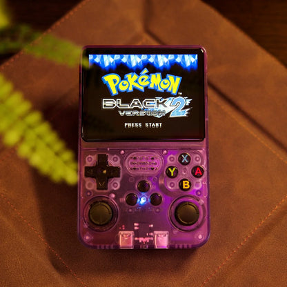 Handheld gaming console displaying 'Pokémon Black Version 2' on a brown surface.